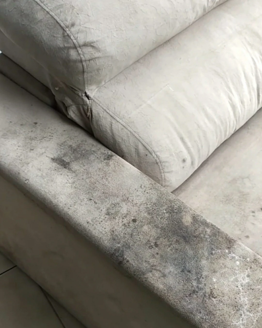 Lateral e encosto do sofá com acúmulo de sujeira e aparência encardida